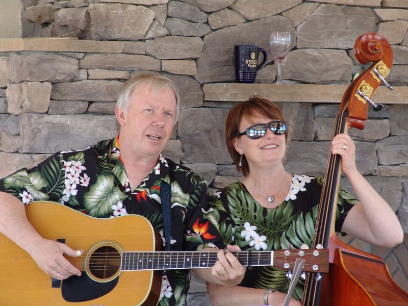 Don playing guitar and Martha playing bass, both with big smiles